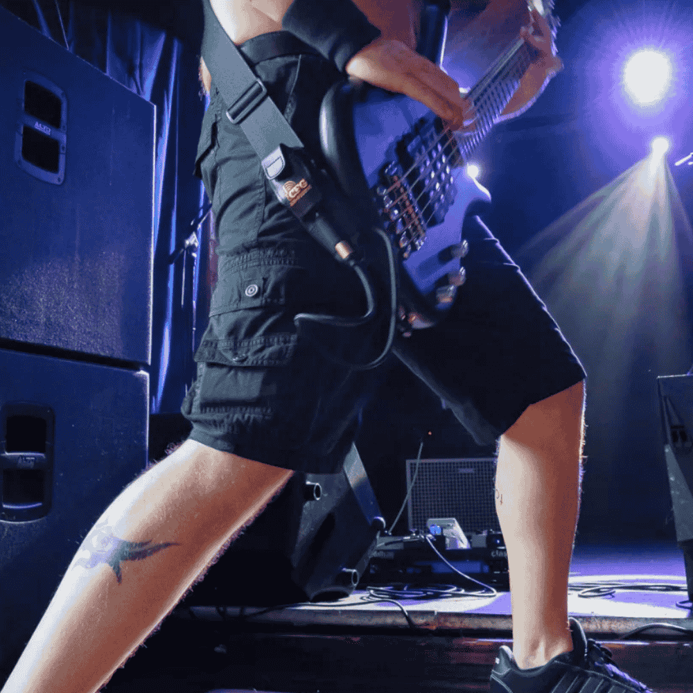 Bassist on stage using CFG Cable Free Guitar's Air-Pocket Transmitter Holster, securely holding a wireless transmitter during live performance